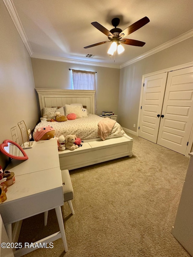 carpeted bedroom featuring ornamental molding, a closet, and ceiling fan