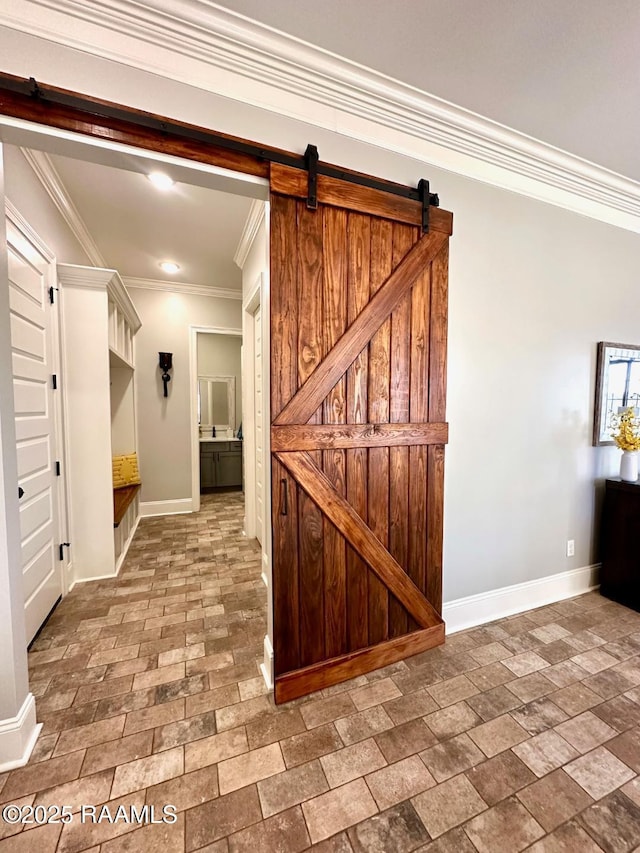 interior space with ornamental molding and a barn door