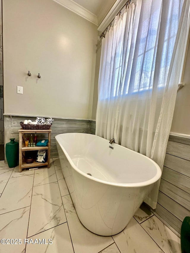 bathroom with ornamental molding and a tub