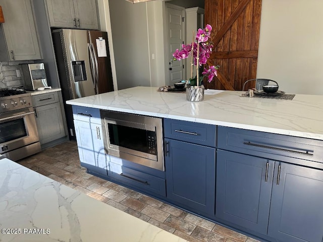 kitchen featuring light stone countertops, appliances with stainless steel finishes, and decorative backsplash