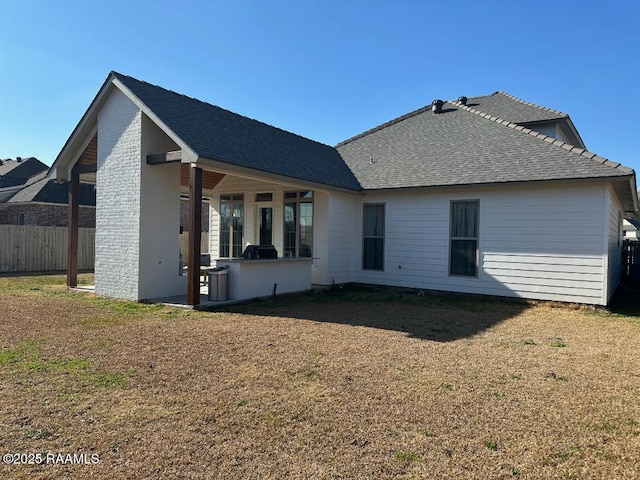 rear view of property with a yard