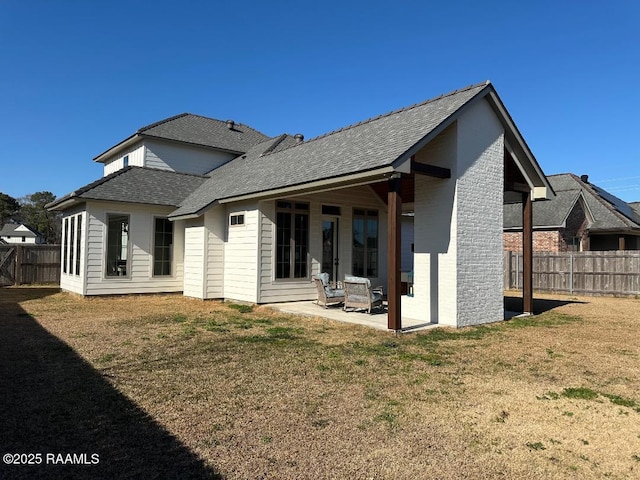 rear view of house with a yard and a patio