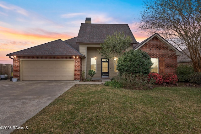 view of front of house with a garage and a lawn