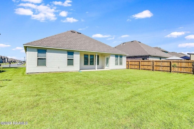 rear view of property featuring a lawn