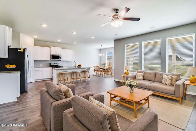 living room with sink, hardwood / wood-style flooring, and ceiling fan