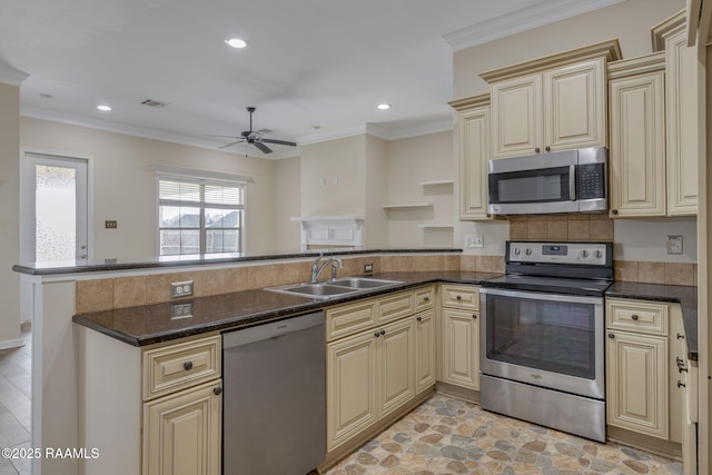 kitchen with kitchen peninsula, appliances with stainless steel finishes, ceiling fan, sink, and dark stone countertops