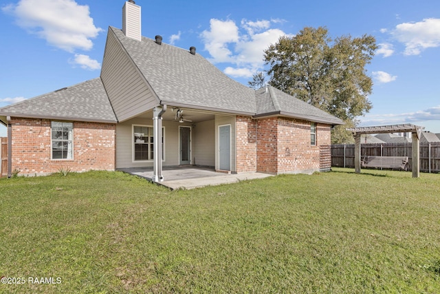 back of property with ceiling fan, a pergola, a patio, and a yard