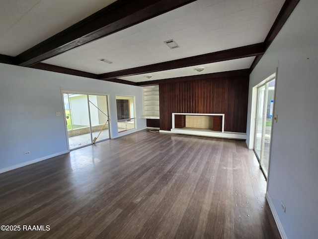 unfurnished living room featuring beamed ceiling and hardwood / wood-style flooring