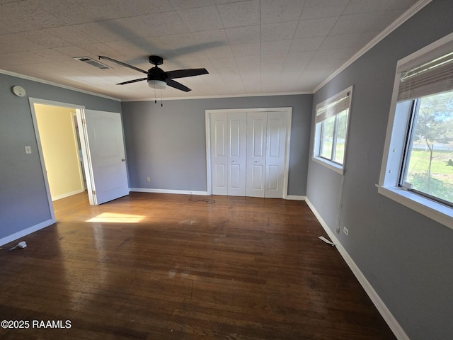 unfurnished bedroom featuring a closet, hardwood / wood-style flooring, ceiling fan, and ornamental molding