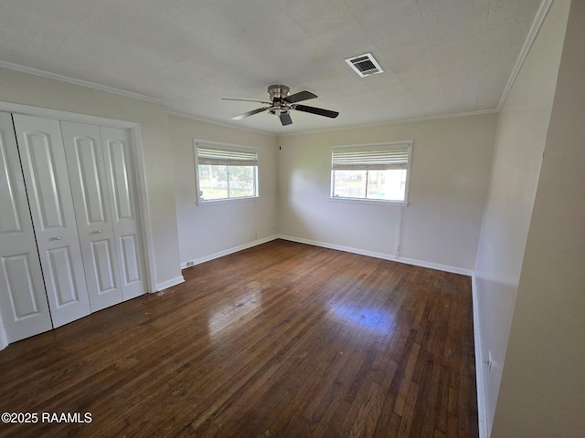 unfurnished bedroom with ceiling fan, a closet, dark hardwood / wood-style floors, and ornamental molding