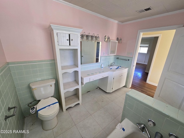 bathroom with tile patterned floors, crown molding, vanity, and toilet