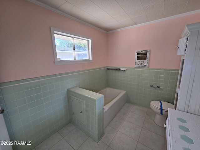 bathroom featuring tile patterned floors, a washtub, tile walls, and ornamental molding