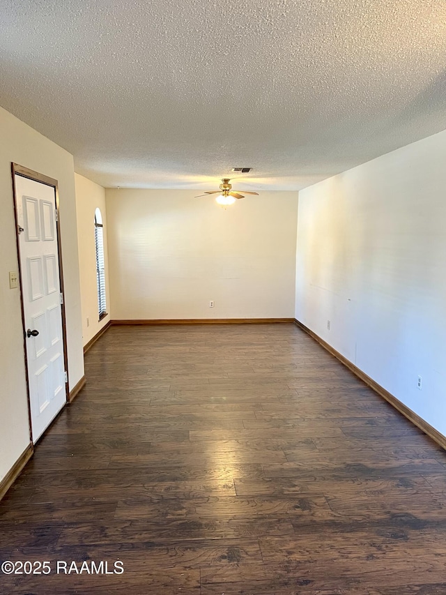 empty room featuring ceiling fan, dark hardwood / wood-style floors, and a textured ceiling