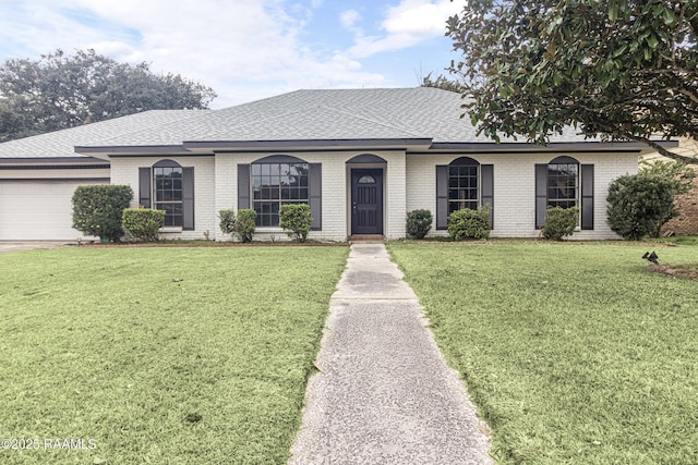 single story home featuring a garage and a front yard