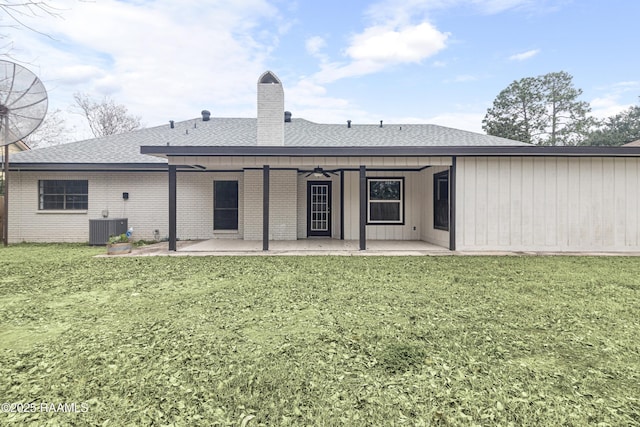 back of property with cooling unit, a patio area, and a lawn