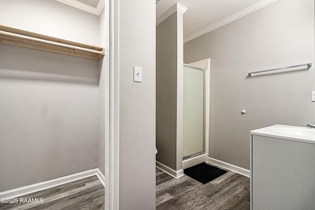 bathroom with an enclosed shower, hardwood / wood-style floors, and crown molding