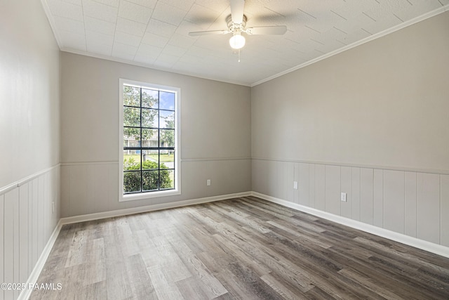 empty room with wood-type flooring, ornamental molding, and ceiling fan