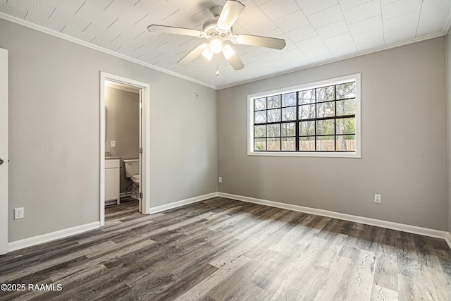 unfurnished bedroom featuring dark wood-type flooring, ceiling fan, ornamental molding, and ensuite bathroom