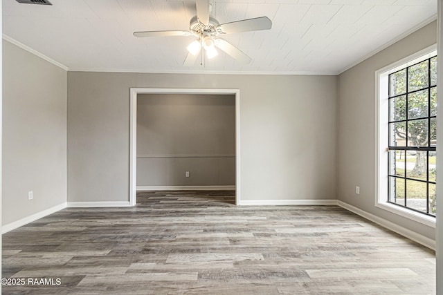 empty room with hardwood / wood-style flooring, ornamental molding, plenty of natural light, and ceiling fan