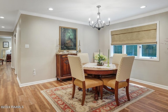 dining room with light hardwood / wood-style flooring, crown molding, and a notable chandelier