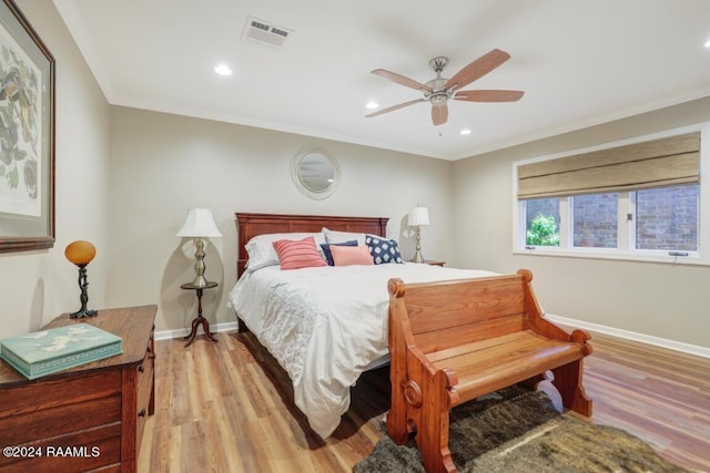 bedroom featuring ceiling fan, crown molding, and light hardwood / wood-style floors