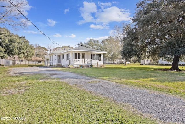 view of front of house with covered porch and a front lawn