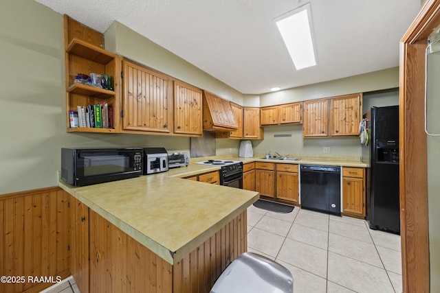 kitchen featuring kitchen peninsula, premium range hood, wooden walls, black appliances, and light tile patterned floors