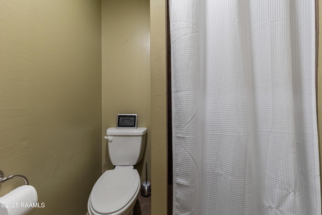 bathroom with toilet and a shower with curtain