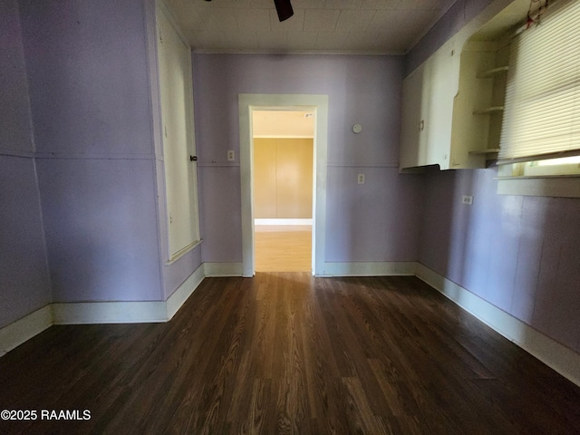 empty room with dark wood finished floors and baseboards