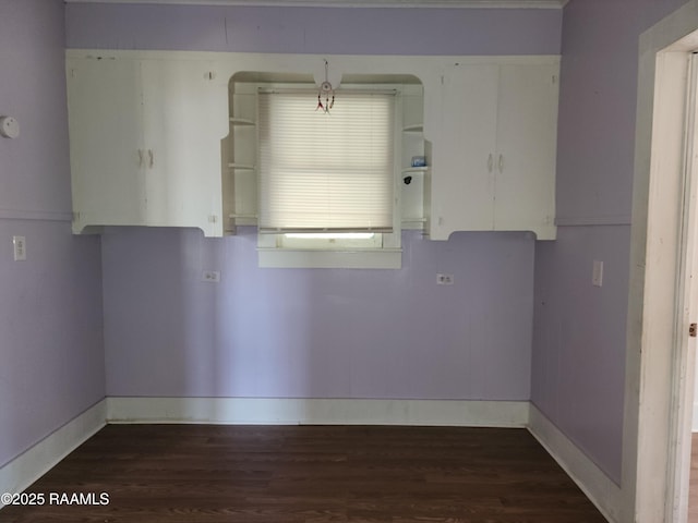 empty room with baseboards and wood finished floors