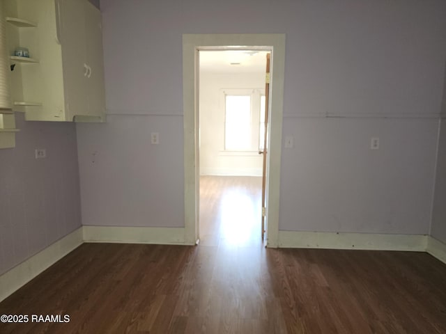 unfurnished room with baseboards and wood finished floors