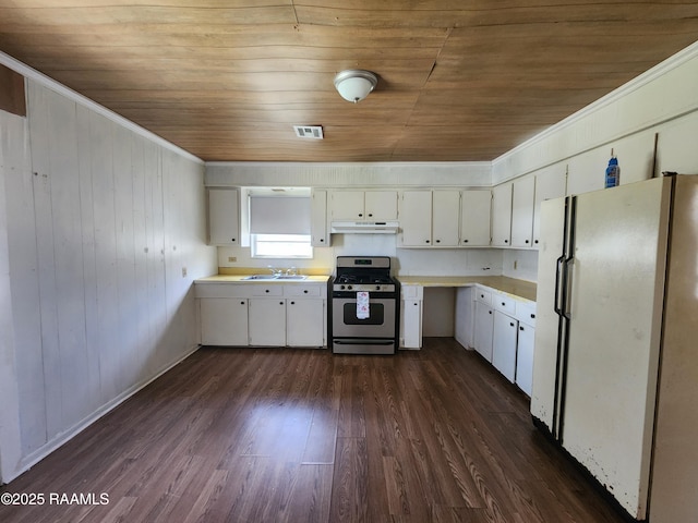 kitchen featuring visible vents, freestanding refrigerator, stainless steel gas range, light countertops, and under cabinet range hood