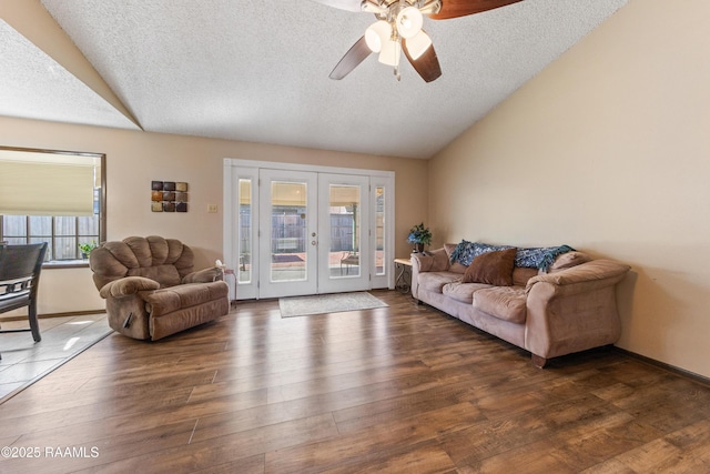 living room with ceiling fan, lofted ceiling, a textured ceiling, and french doors