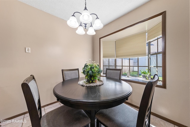 dining area with light tile patterned flooring, a textured ceiling, and an inviting chandelier