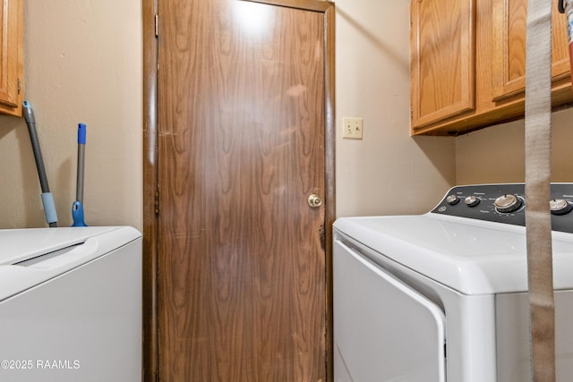 laundry area with separate washer and dryer and cabinets