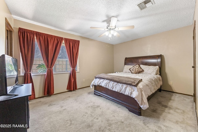 carpeted bedroom with ceiling fan and a textured ceiling