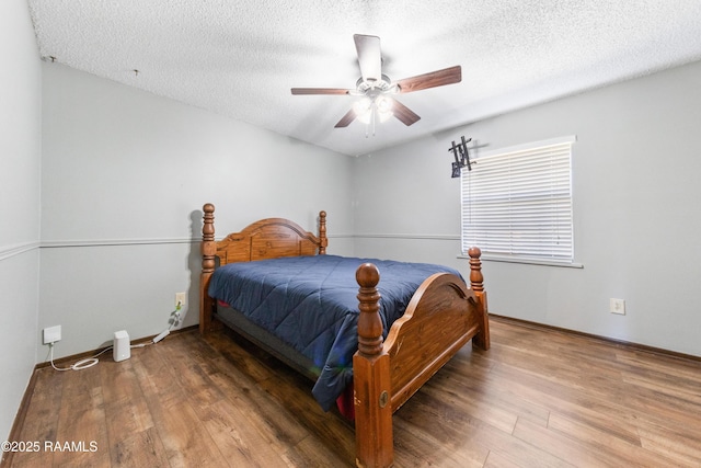 bedroom with hardwood / wood-style floors, ceiling fan, and a textured ceiling