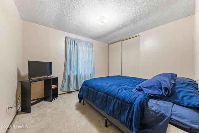 carpeted bedroom with a textured ceiling and a closet