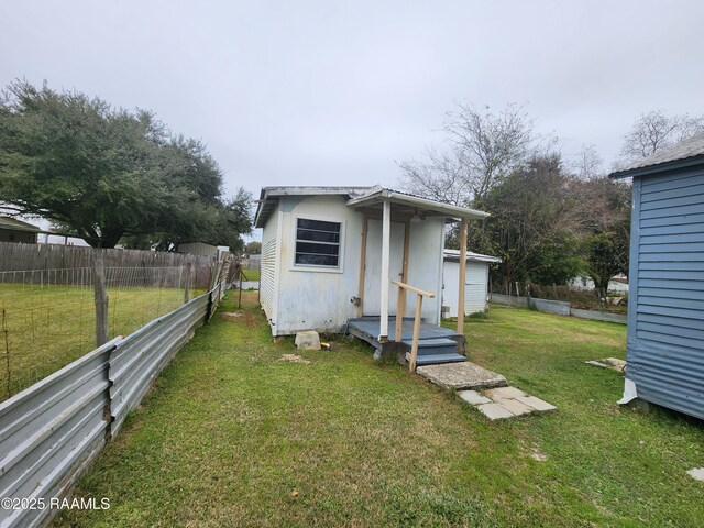 view of outdoor structure with fence and an outbuilding