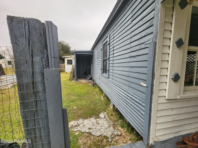 view of side of home featuring a yard and fence