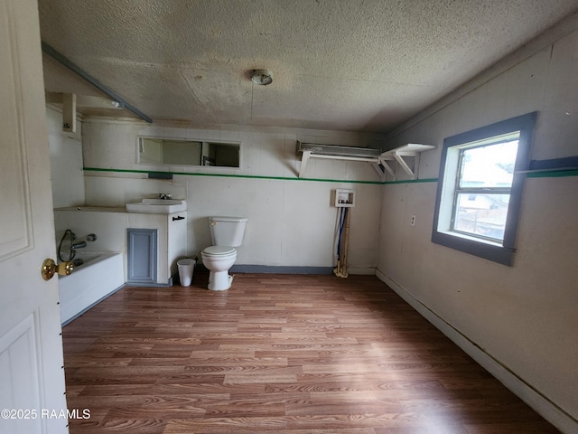 bathroom featuring a tub to relax in, vanity, toilet, and wood finished floors