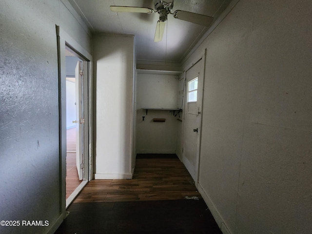 corridor with a textured wall and wood finished floors