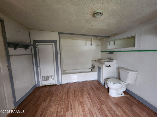 bathroom featuring a textured ceiling, toilet, wood finished floors, vanity, and baseboards