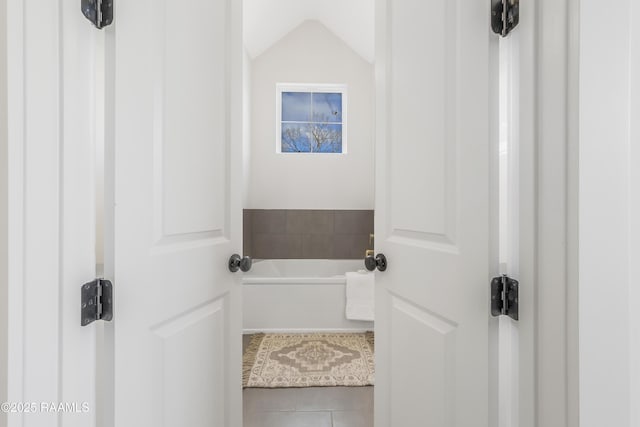 bathroom with tile patterned floors and a bathtub