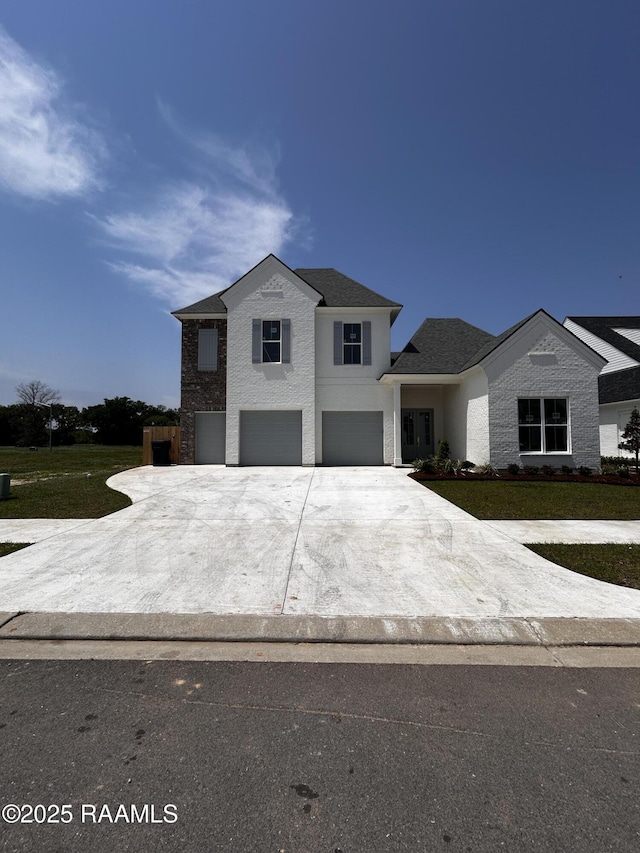 view of front of home featuring a front yard, an attached garage, driveway, and stucco siding