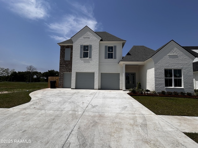 traditional home with a garage, a front yard, brick siding, and driveway
