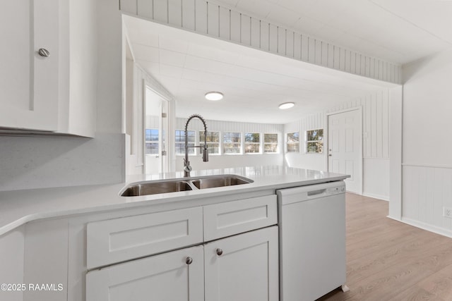 kitchen featuring dishwasher, light wood-type flooring, white cabinetry, and sink