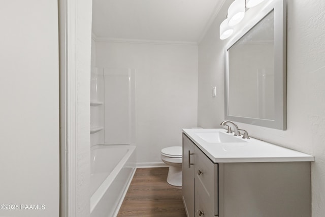 full bathroom featuring ornamental molding, toilet, vanity, bathtub / shower combination, and hardwood / wood-style flooring