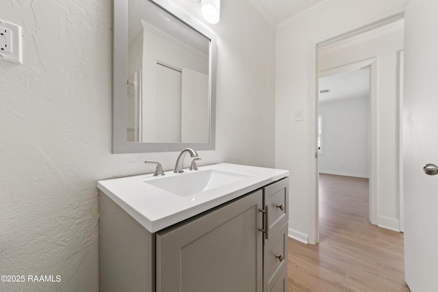 bathroom featuring vanity, wood-type flooring, and crown molding