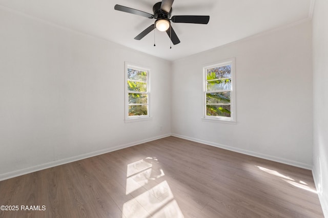 spare room featuring hardwood / wood-style floors, a wealth of natural light, ornamental molding, and ceiling fan